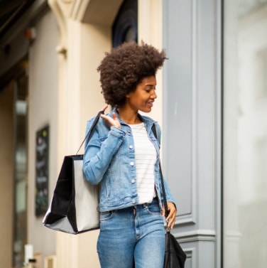 lady in denim walking with shopping bags
